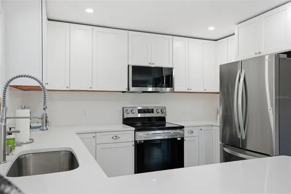 a kitchen with white cabinets and stainless steel appliances