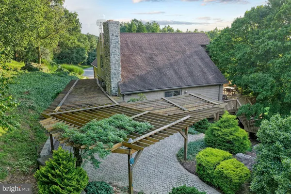 a view of backyard with large trees and wooden fence