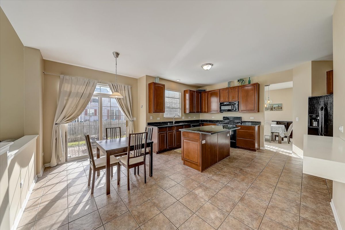 406 Aviary Lane Bolingbrook, IL 60490 - Photo 15 of 46 a kitchen with a table chairs sink and cabinets