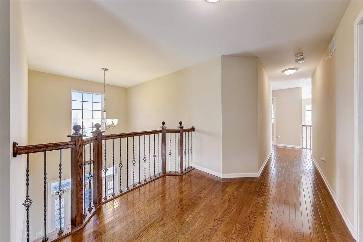 406 Aviary Lane Bolingbrook, IL 60490 - Photo 25 of 46 a view of a hallway with wooden floor and windows