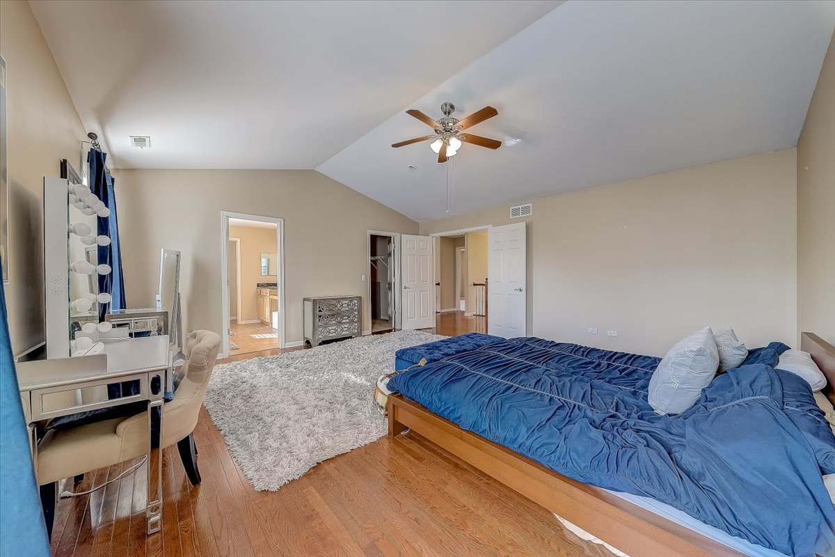 406 Aviary Lane Bolingbrook, IL 60490 - Photo 28 of 46 a bedroom with a large bed and a chandelier