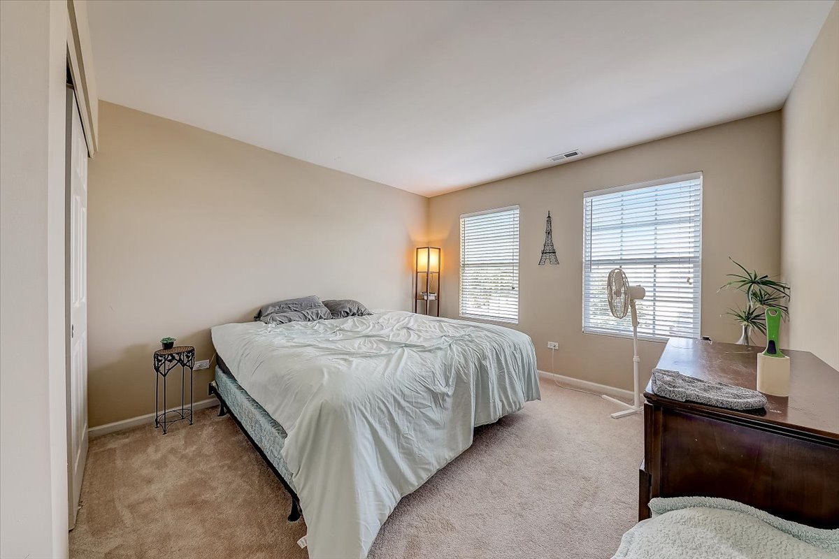 406 Aviary Lane Bolingbrook, IL 60490 - Photo 36 of 46 a spacious bedroom with a bed and wooden floor