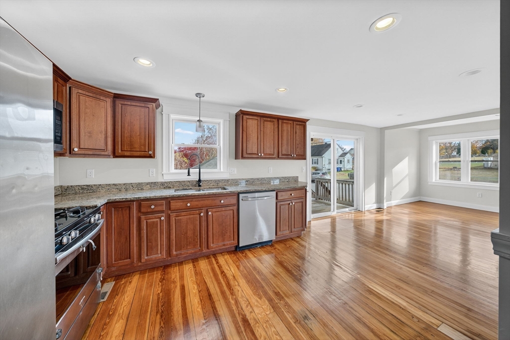 228 Dickinson Street Fall River, MA 02721 - Photo 7 of 40 a kitchen with stainless steel appliances granite countertop wooden cabinets a stove top oven a sink and dishwasher with wooden floor