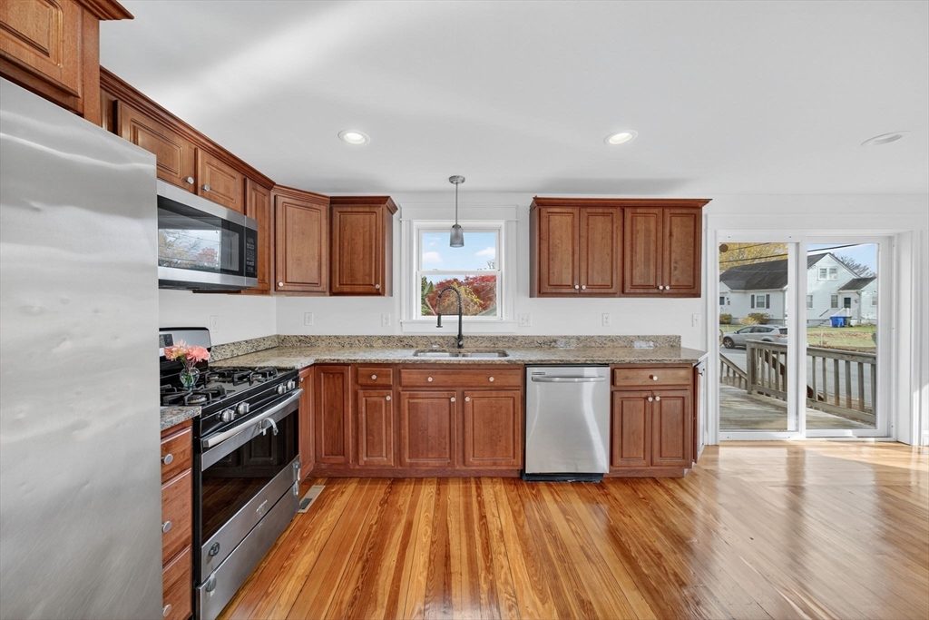 228 Dickinson Street Fall River, MA 02721 - Photo 8 of 40 a kitchen with stainless steel appliances granite countertop wooden cabinets a stove top oven a sink and dishwasher
