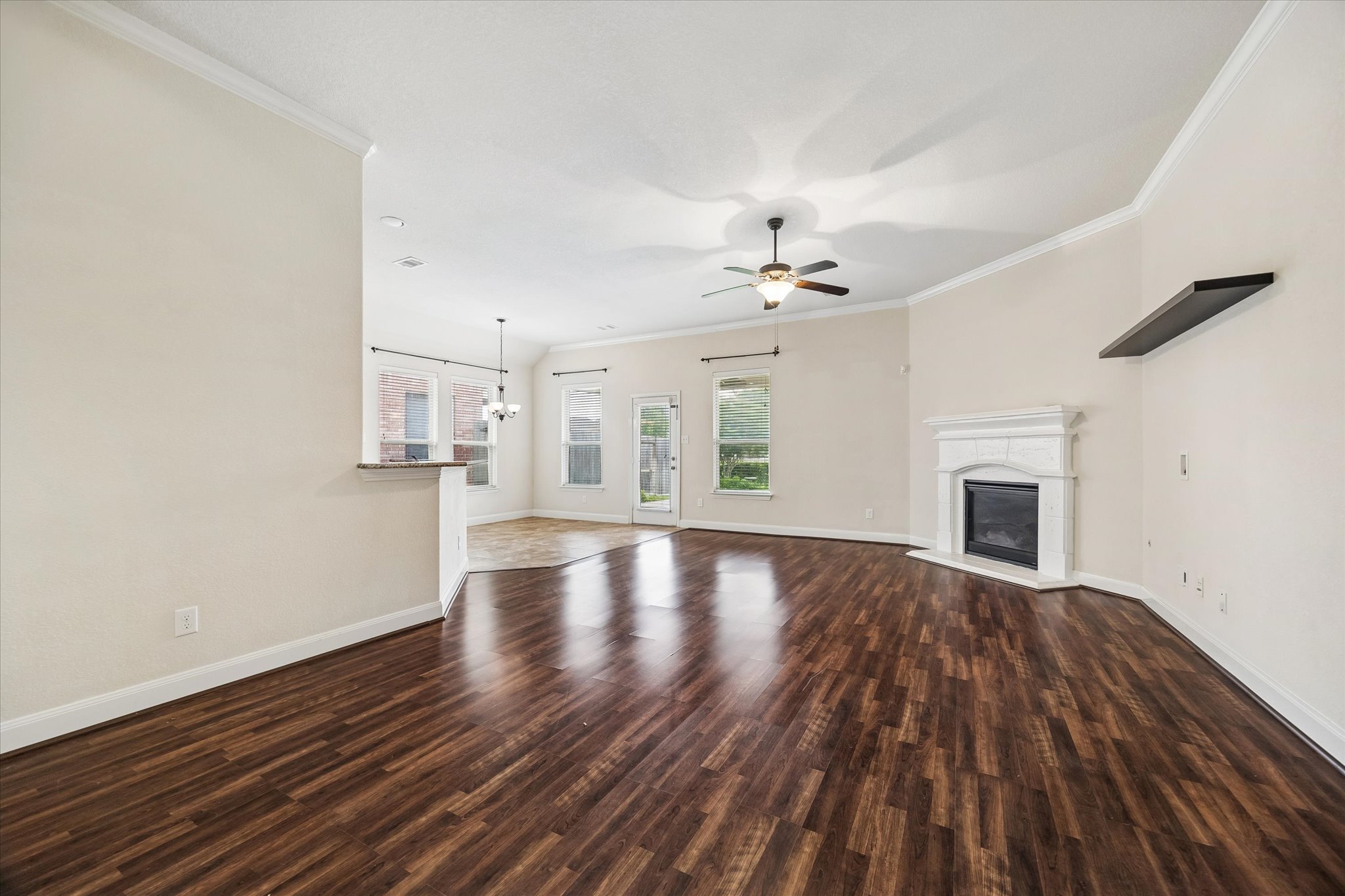 2214 Wembley Way Rosenberg, TX 77471 - Photo 11 of 35 Spacious living area featuring rich wood-finish flooring, a white mantel fireplace, and crown molding