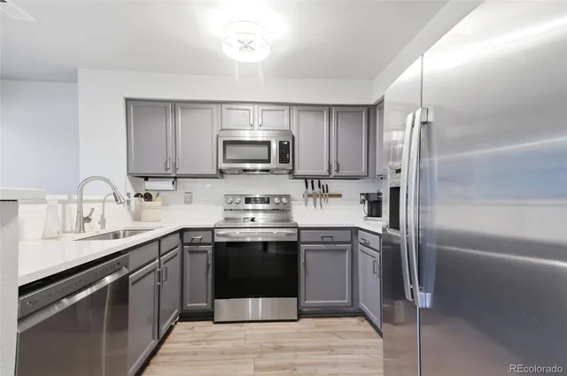 a kitchen with kitchen island granite countertop a sink stainless steel appliances and white cabinets