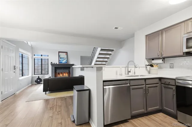 a kitchen with stainless steel appliances a sink stove and wooden cabinets