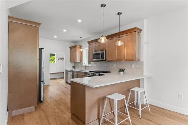 a kitchen with granite countertop a stove a sink and a refrigerator