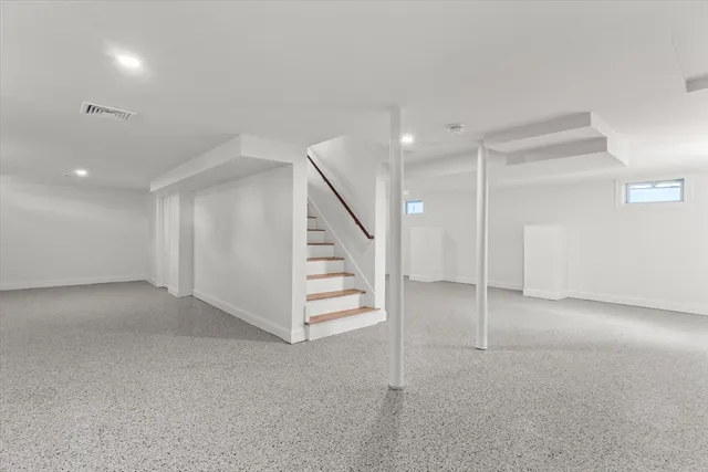 an empty room with staircase and white walls