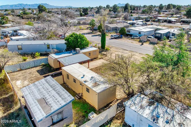 an aerial view of a house with a yard basket ball court and city view