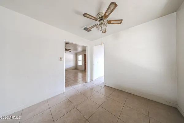 an empty room and a chandelier fan