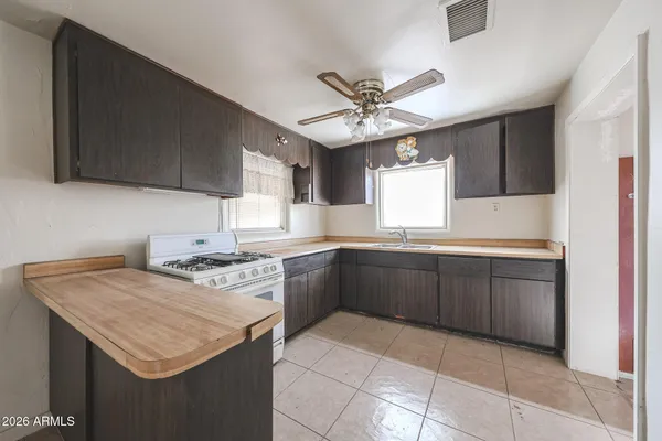 a kitchen with a sink a stove and cabinets