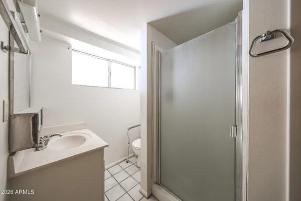 a bathroom with a granite countertop sink mirror vanity and toilet