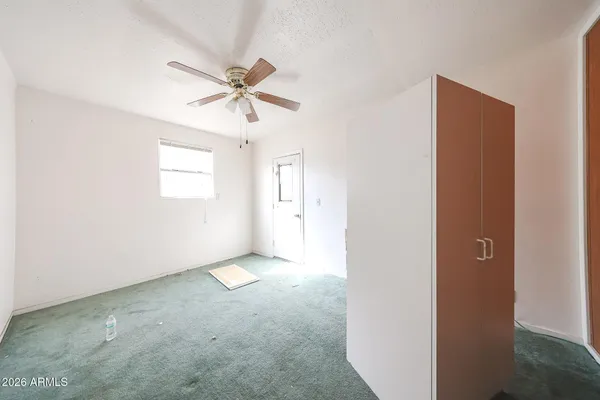 en empty room with windows and fan