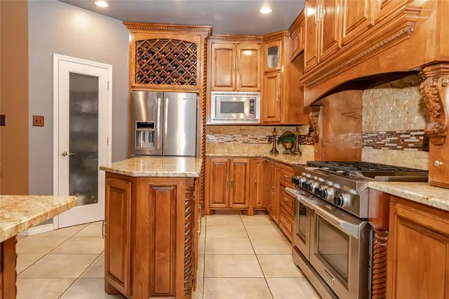 a kitchen with stainless steel appliances granite countertop a stove a sink and a refrigerator