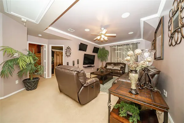a living room with furniture a chandelier and a flat screen tv