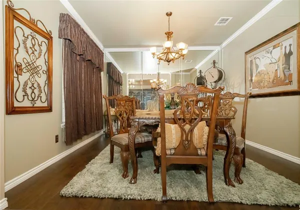 a view of a dining room with furniture a rug and wooden floor