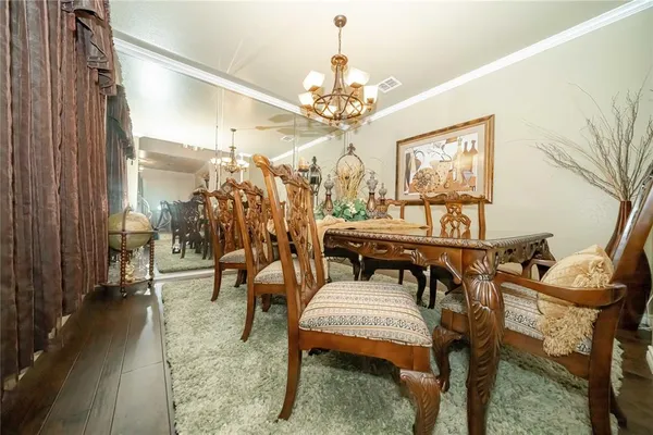 a living room with furniture a chandelier and a dining table