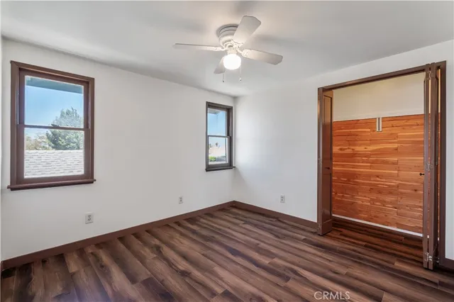 a view of an empty room with window and wooden floor