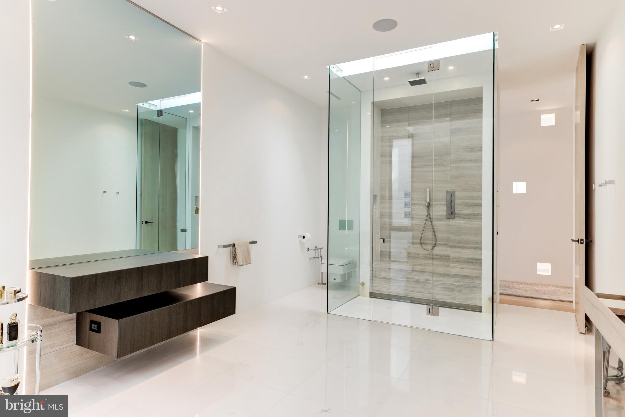 410 Chain Bridge Road McLean, VA 22101 - Photo 22 of 26 a spacious bathroom with a shower a sink and a mirror