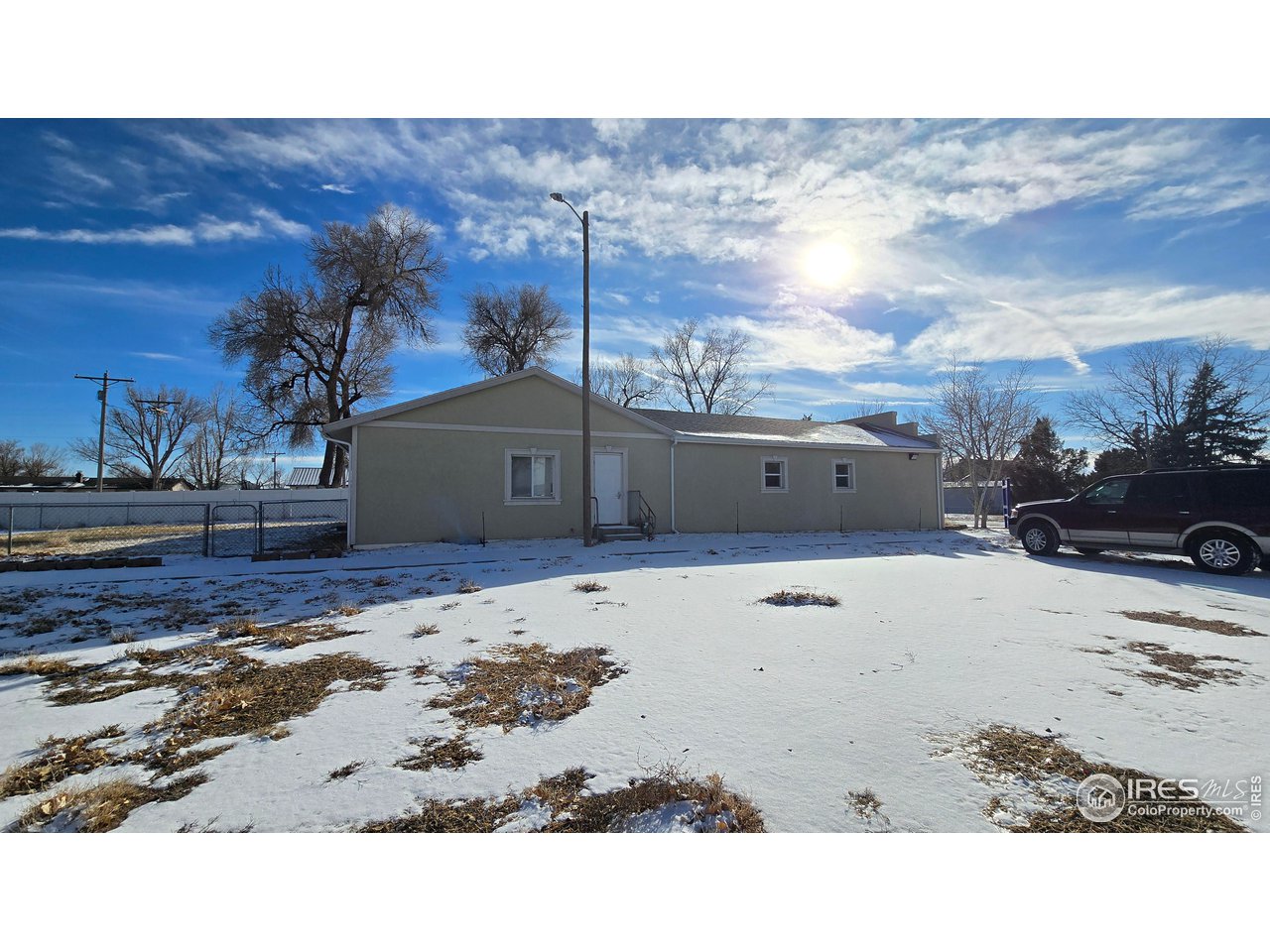 118 Dickson Street Wiggins, CO 80654 - Photo 4 of 34 FROM PARKING LOT SHOWING FENCED IN BACK YARD