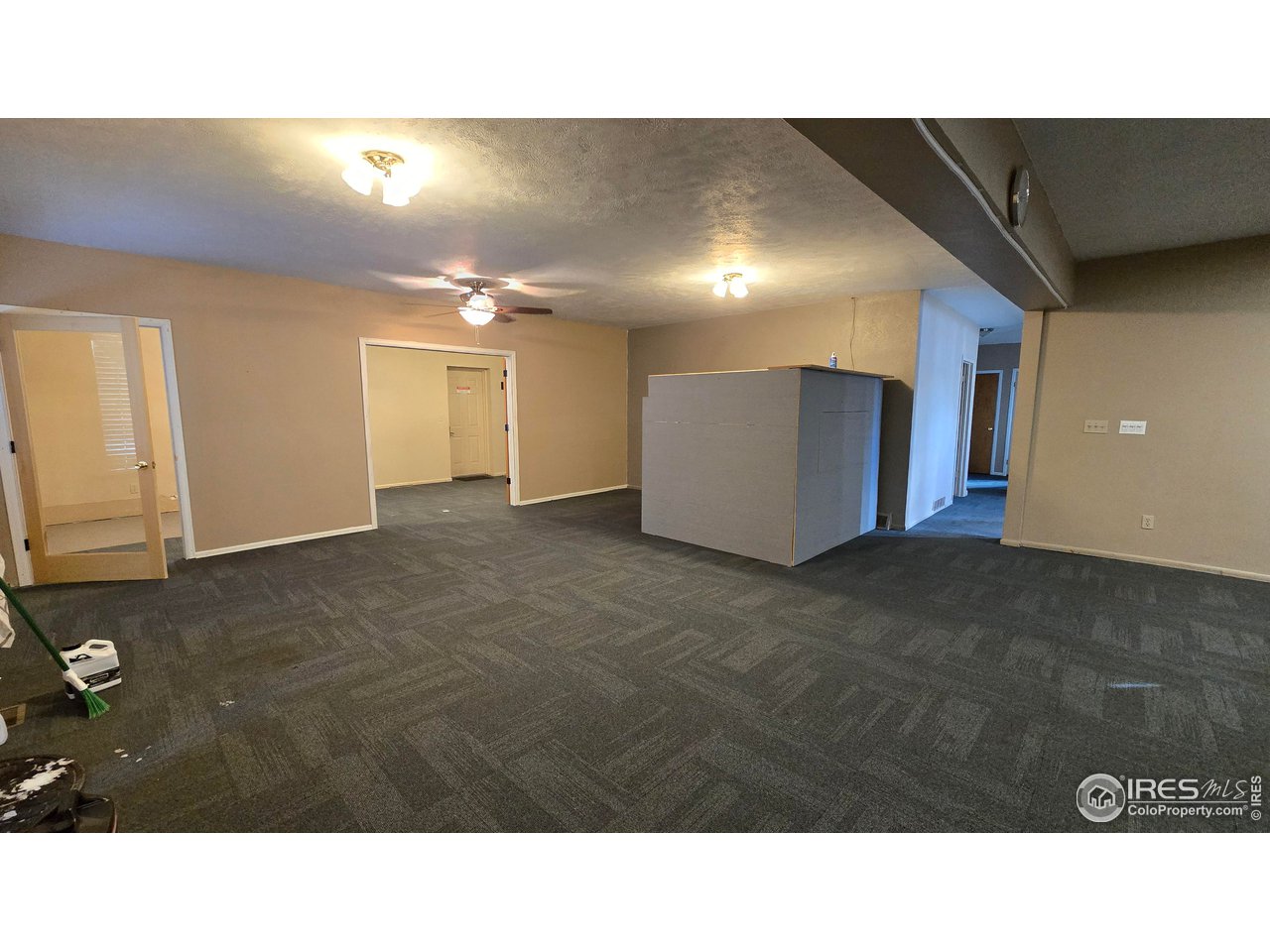 118 Dickson Street Wiggins, CO 80654 - Photo 7 of 34 MAIN AUDITORIUM LOOKING DOWN THE HALL ON THE LEFT AND THE BACK ROOM LEADING TO KITCHEN ON THE RIGHT