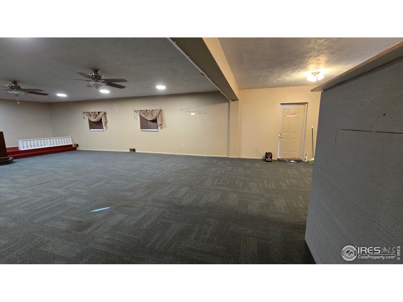 118 Dickson Street Wiggins, CO 80654 - Photo 8 of 34 MAIN AUDITORIUM FROM THE MAIN ENTRY HALLWAY DOOR AT THE RIGHT TO THE PARKING LOT