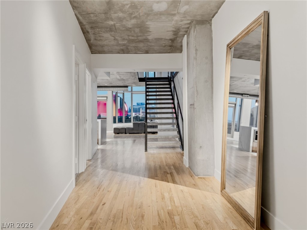 360 East Desert Inn Road, Unit 607 Las Vegas, NV 89109 - Photo 35 of 55 Bright hardwood floors lead to a sleek staircase, connecting levels with urban vistas.