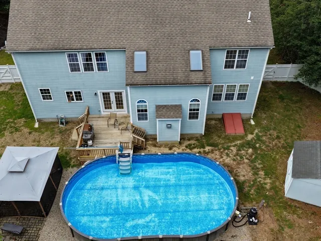 an aerial view of a house with swimming pool and porch
