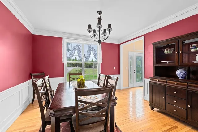 a view of a dining room with furniture a chandelier and wooden floor