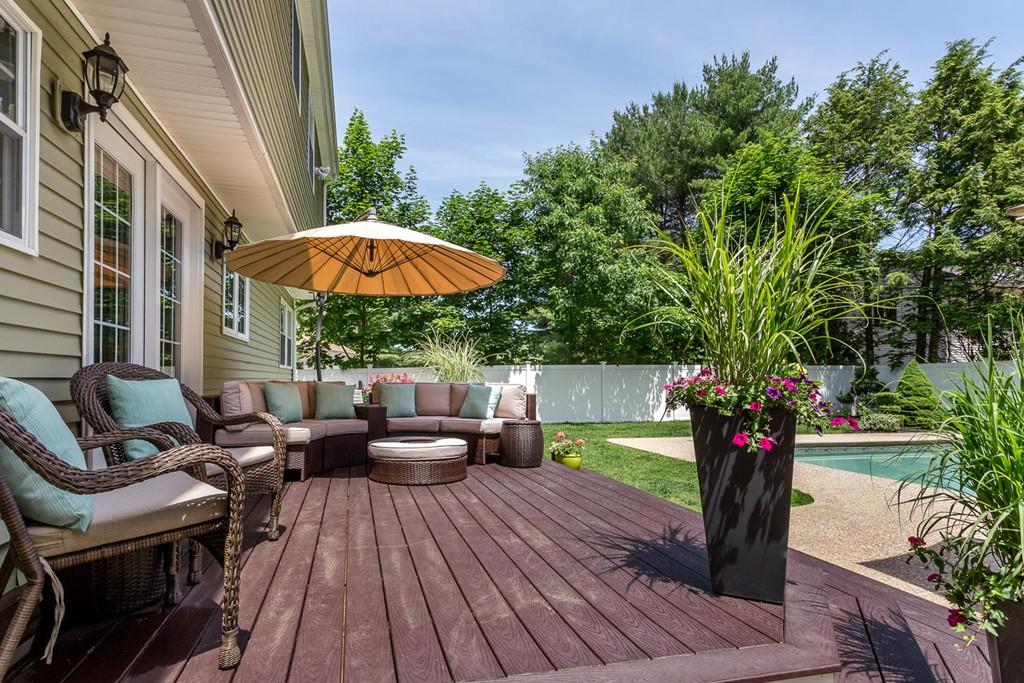 17 Fairview Road Canton, MA 02021 - Photo 35 of 40 a view of a patio with couches table and chairs under an umbrella with wooden floor
