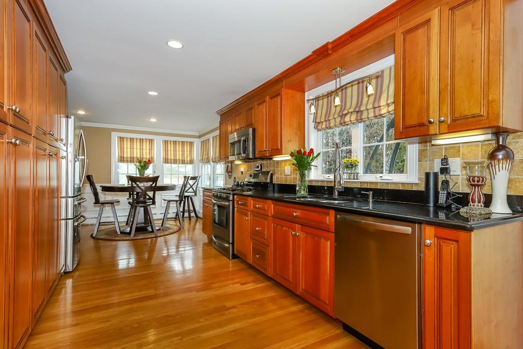 17 Fairview Road Canton, MA 02021 - Photo 9 of 40 a kitchen with stainless steel appliances granite countertop a refrigerator a sink dishwasher a stove and a dining table with wooden floor
