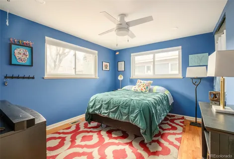 a bedroom with a bed and a lamp on dresser