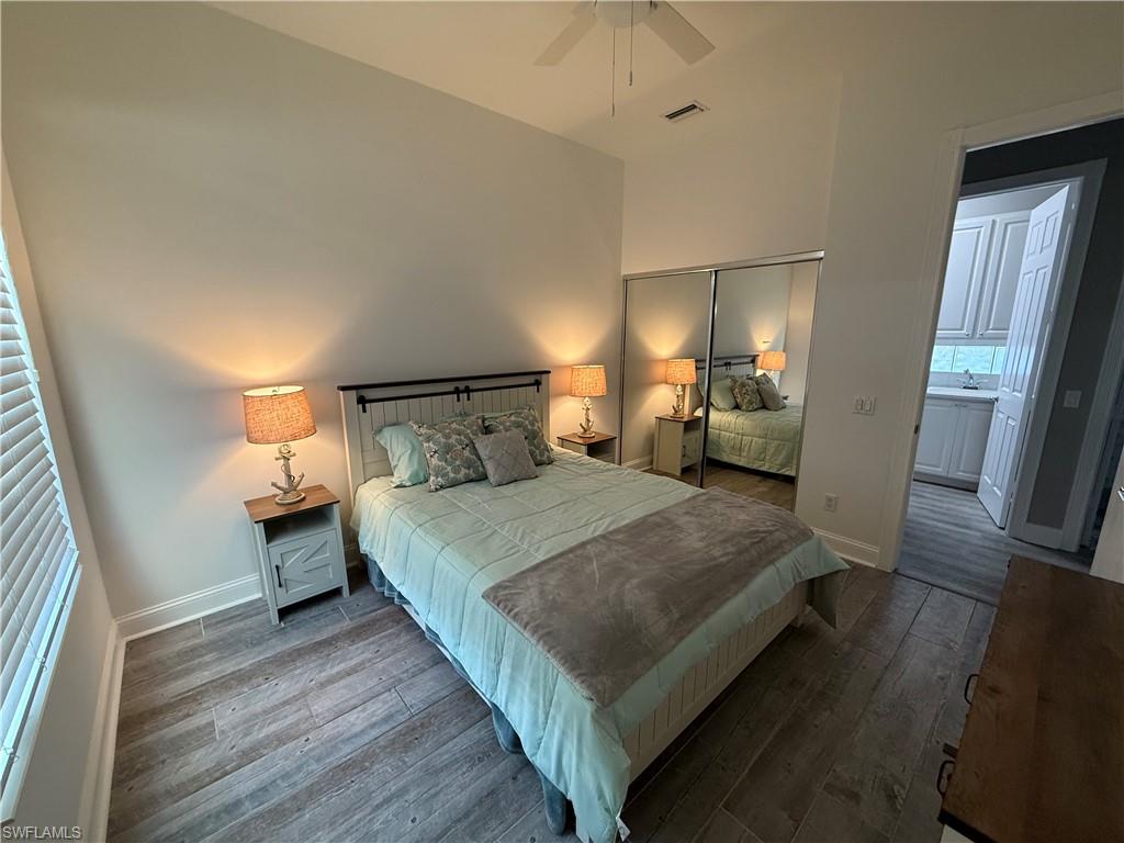 7549 Garibaldi Court Naples, FL 34114 - Photo 12 of 15 Bedroom with dark wood-style floors, a closet, and a ceiling fan