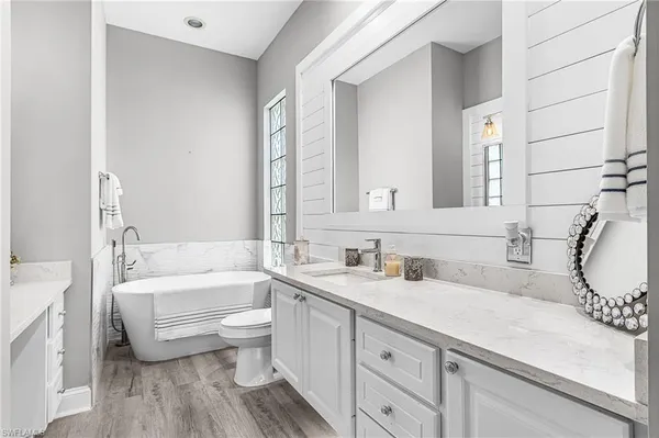 a bathroom with a sink a toilet and a large mirror