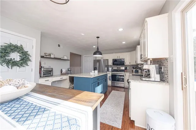a kitchen with sink refrigerator dining table and chairs