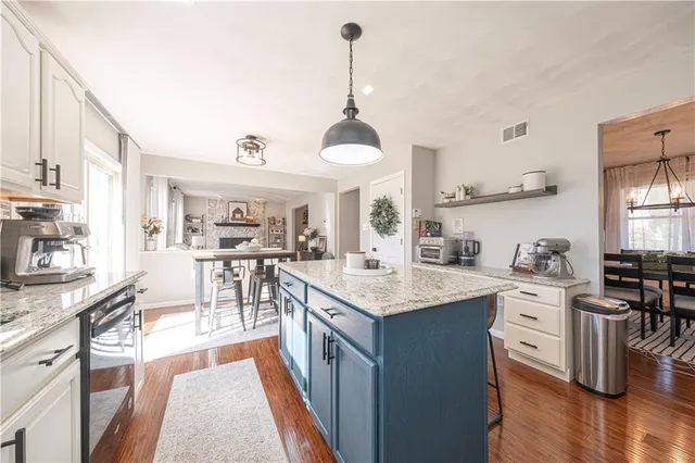a kitchen with stainless steel appliances granite countertop a sink stove and wooden floor