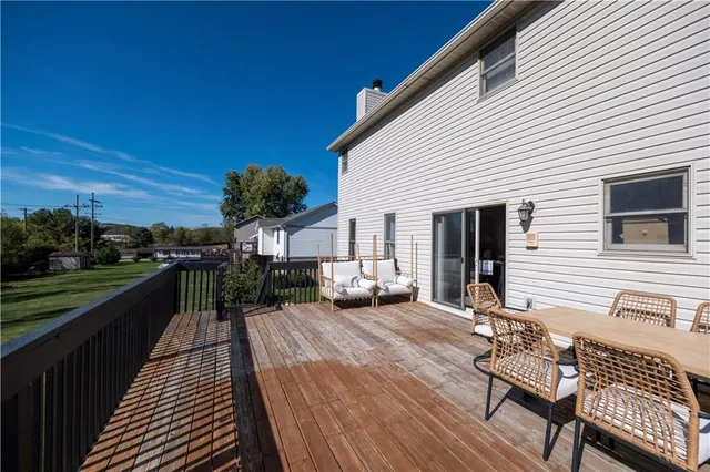 a view of a roof deck with table and chairs the wooden floor & fence
