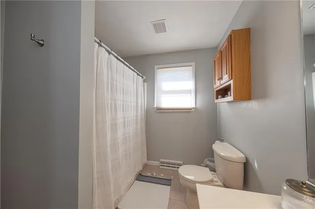 a white toilet sitting next to a bathroom sink and vanity