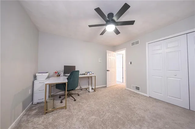 a view of a workspace with furniture and a window