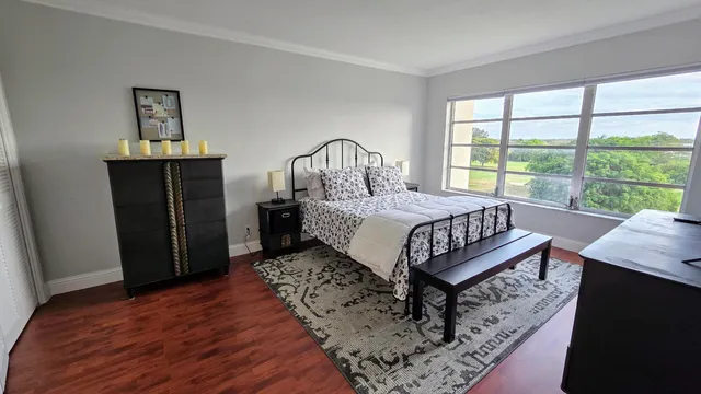 a bedroom with a bed next to a window with a dresser