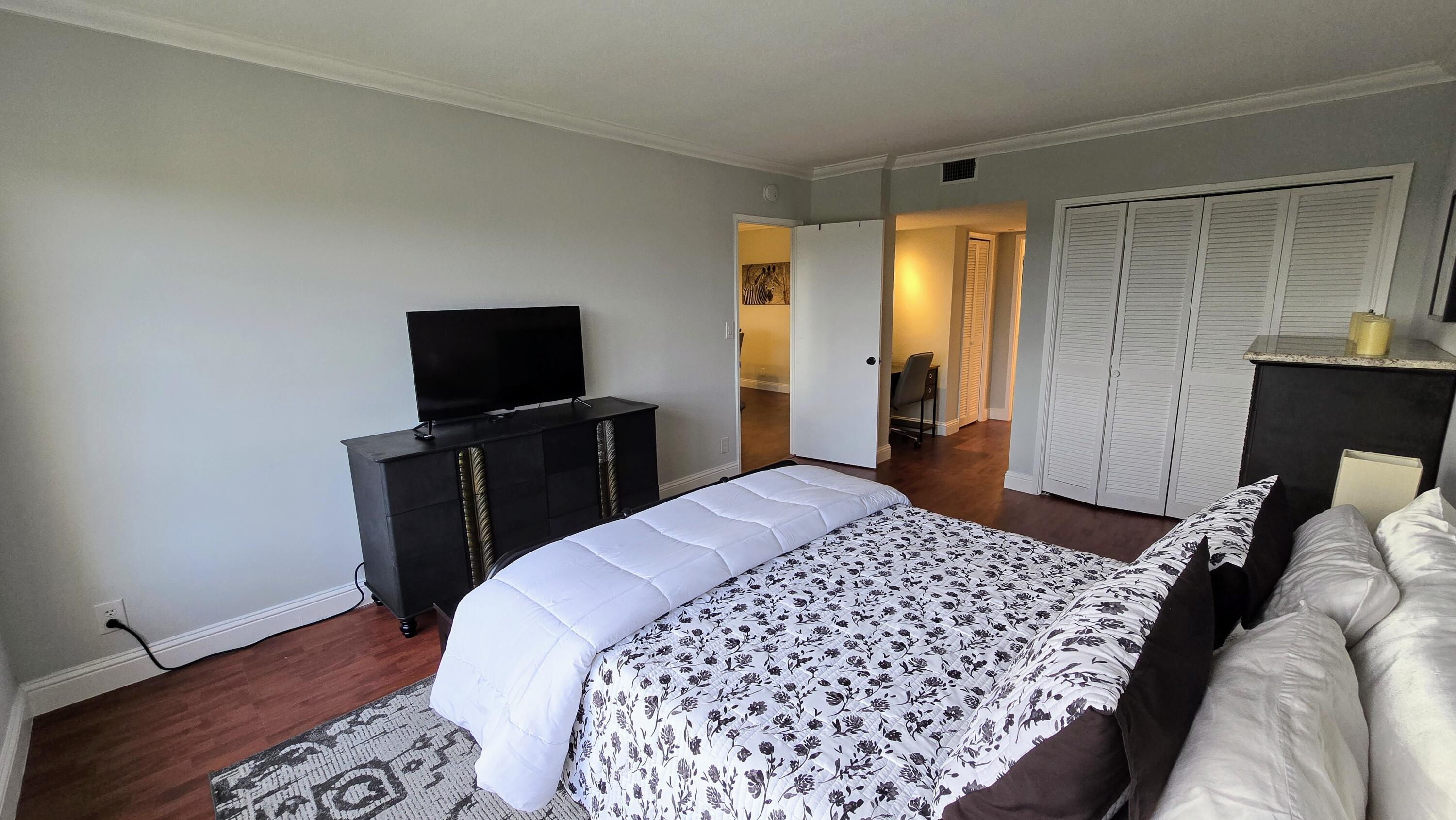 3100 North Palm Aire Drive, Unit 604 Pompano Beach, FL 33069 - Photo 14 of 25 a bedroom with a bed and a flat screen tv