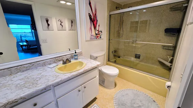 a bathroom with a granite countertop sink a toilet and shower