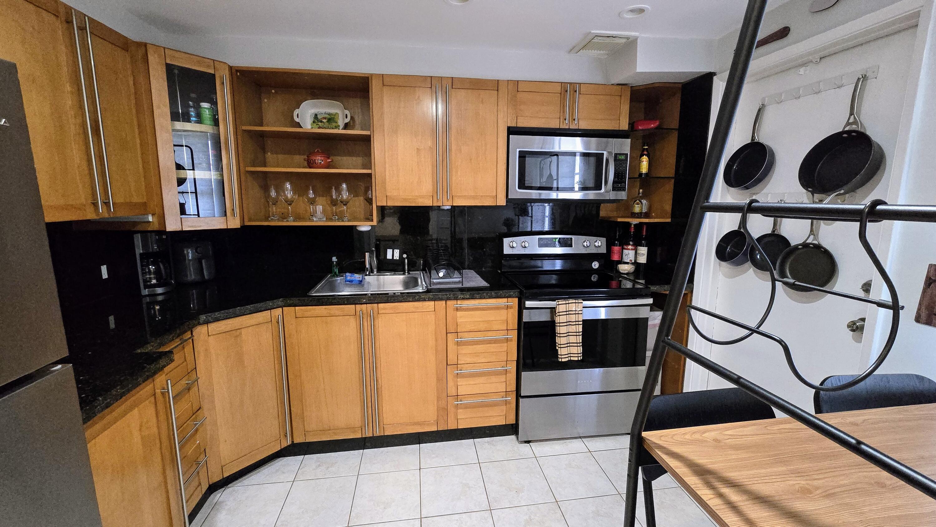 3100 North Palm Aire Drive, Unit 604 Pompano Beach, FL 33069 - Photo 10 of 25 a kitchen with stainless steel appliances granite countertop a sink and a stove