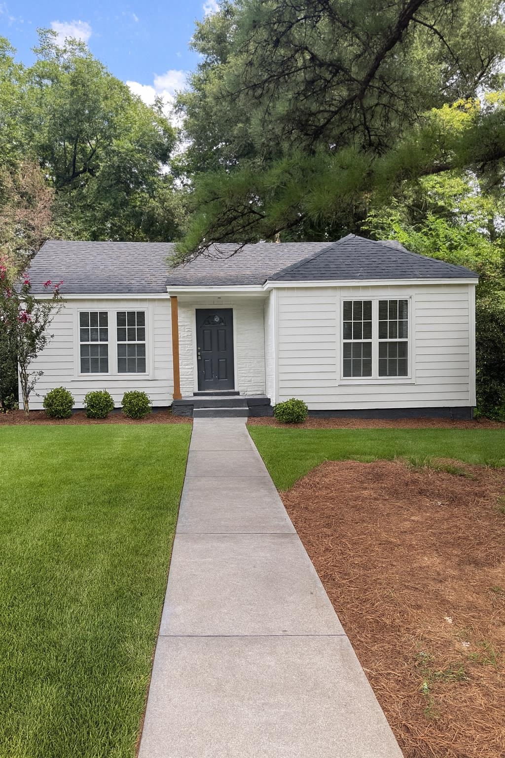 1628 Cherry Road Memphis, TN 38117 - Photo 1 of 1 a front view of a house with a garden and trees