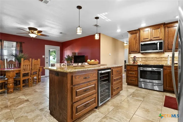 a kitchen with granite countertop stainless steel appliances and wooden cabinets