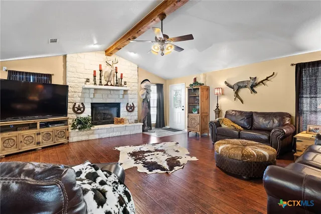 a living room with furniture a flat screen tv and a fireplace
