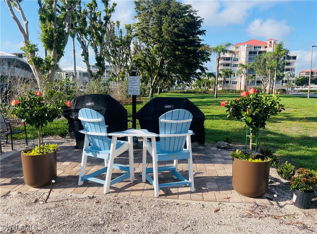 1020 South Collier Boulevard, Unit 507 Marco Island, FL 34145 - Photo 24 of 25 a view of a patio with table and chairs potted plants and swimming pool