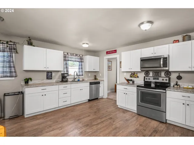 a kitchen with granite countertop white cabinets stainless steel appliances and sink