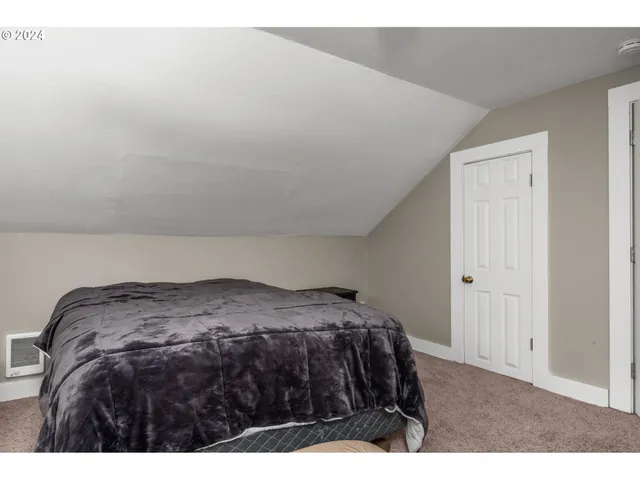 a bedroom with a bed with wooden floor